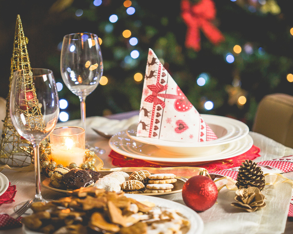 Kalėdų stalas su indais, sausainiais ir dekoracijomis