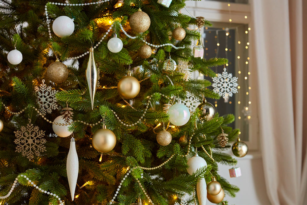 Kalėdų eglutė su aukso, sidabro ir baltos spalvos papuošalais.