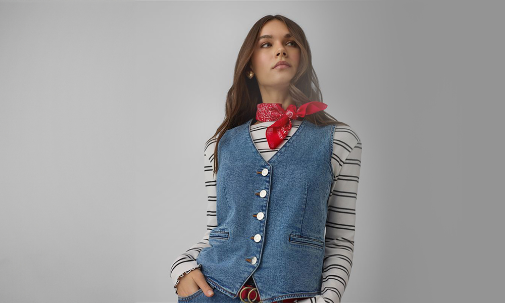 Moteris vilki mėlyną džinsinį liemenę ir raudoną bandaną aplink kaklą.